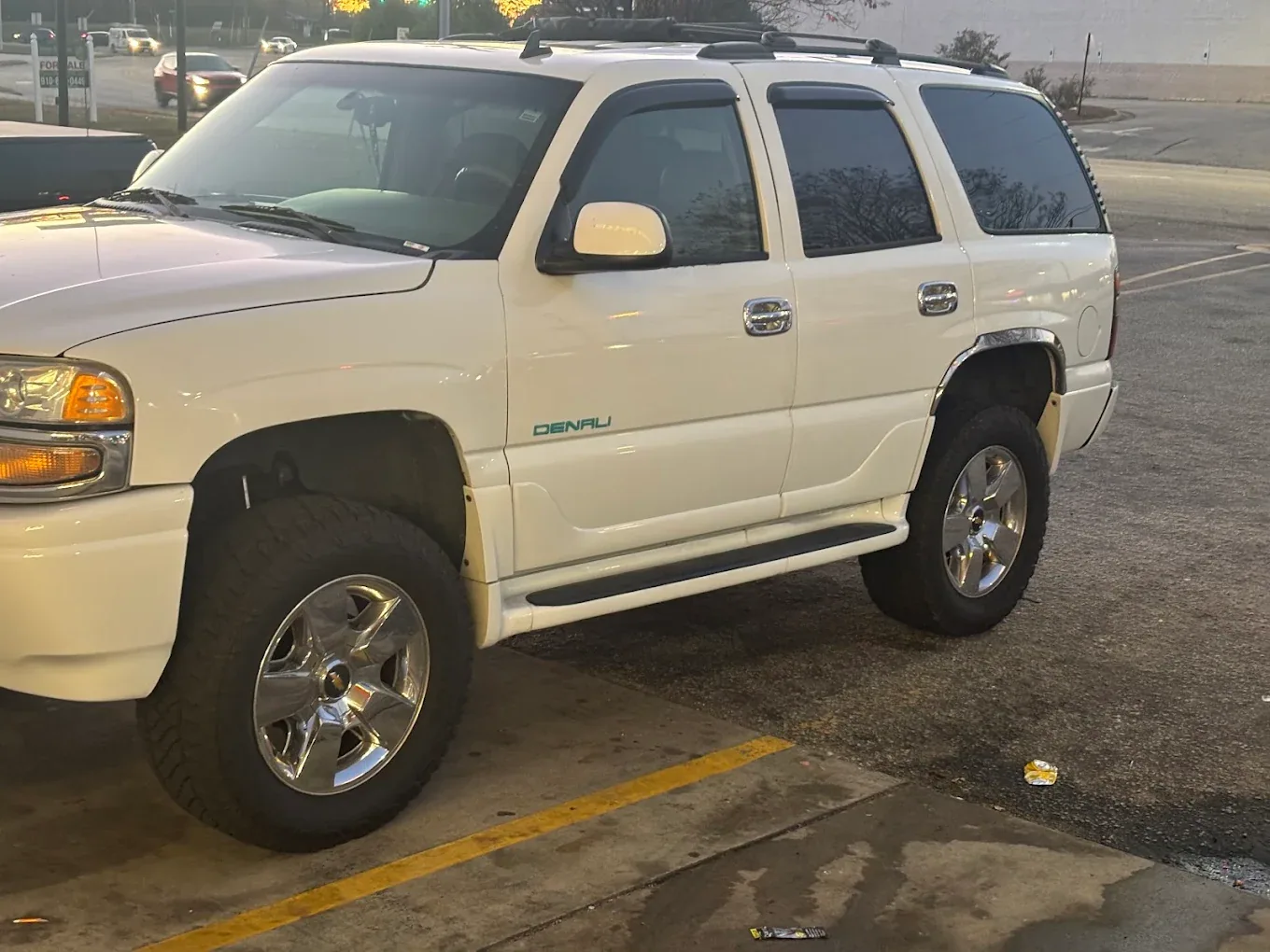 A white GMC Yukon outside the shop