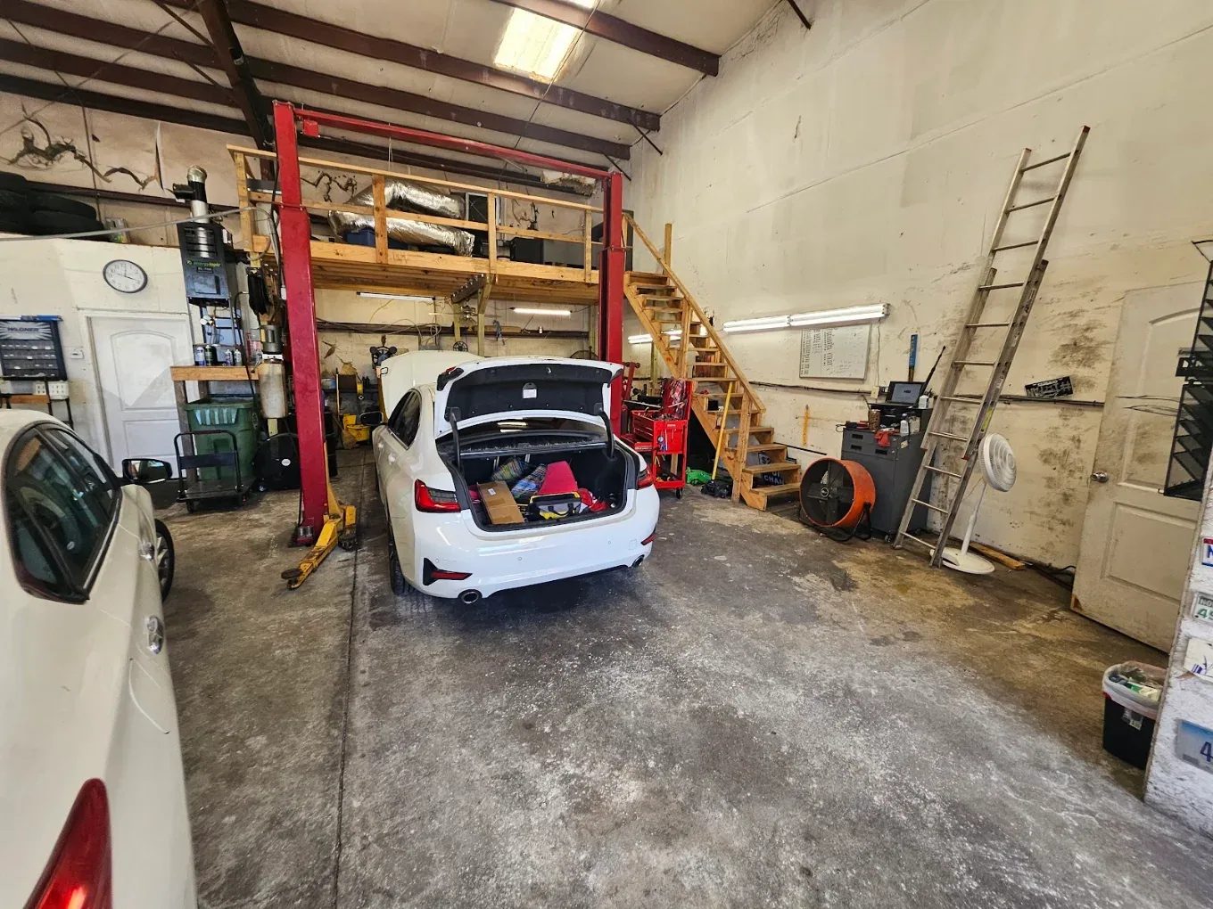 A sedan on a two post lift in the shop